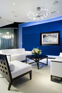 Sit Down Area With Couch on Right and Left With Chair, Coffee Table in The Middle and TV on Wall in America’s Mattress Showroom Located in Las Vegas, Nevada
